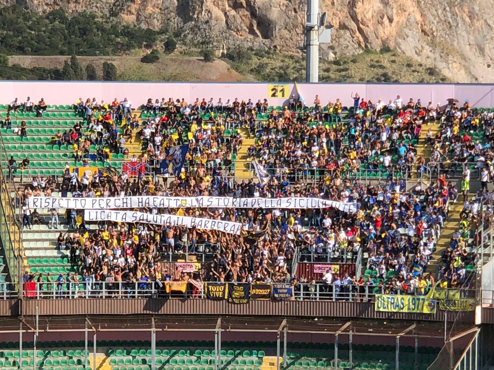 whatsapp-image-2019-10-20-at-14-54-35 Bello striscione dei tifosi del Licata esposto al “Barbera”. Il settore ospiti dello stadio rosanero è gremito e il popolo gialloblù ha voluto rendere omaggio al Palermo con un messaggio di ringraziamento. “Rispetto per chi ha fatto la storia della Sicilia intera, Licata saluta il Barbera“, questo il testo scelto dai tifosi, che non hanno avuto il minimo problema con il popolo rosanero. Nessuno scontro o problemi di sorta, solo grande entusiasmo per una partita storica per il Licata e tutta la sua gente. LEGGI ANCHE PALERMO – LICATA, LA DIRETTA TESTUALE SERIE D, I RISULTATI DELL’8a GIORNATA